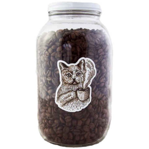 A 64oz glass jar filled with coffee beans, featuring a metal lid and a black and white illustration of a cat on the front.