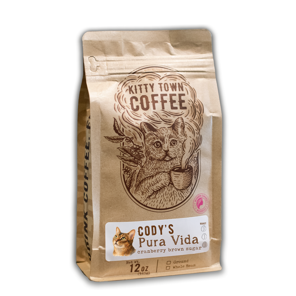 A 12 oz bag of Cody's Pura Vida with the Kitty Town cat illustration and a photo of Cody