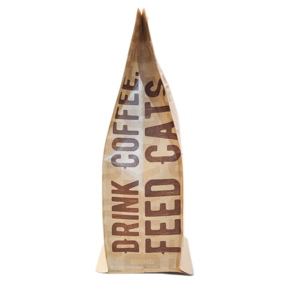 A side view of a 12oz bag of Kitty Town Coffee which says, "Drink Coffee Feed Cats"