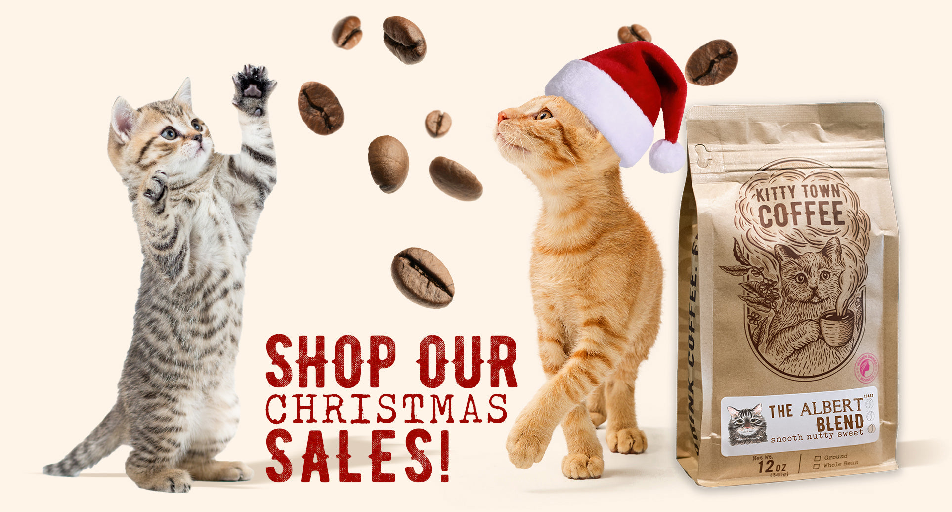 Two cats with a coffee bag and coffee beans on a beige background, promoting Christmas sales.