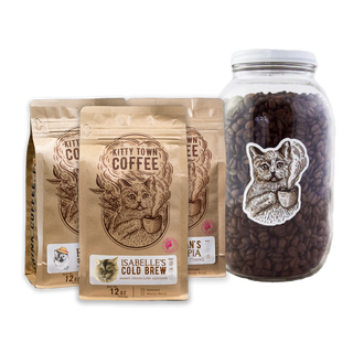 A collection of coffee-related items including three bags of coffee beans labeled 'Kitty Town Coffee' with different names, and a large 64oz glass jar with a metal lid, containing coffee beans and featuring a cat graphic.