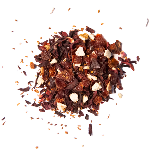 A close-up of loose tea leaves and pieces, including hibiscus flowers and possible currant pieces, indicative of the product's berry and rooibos base.