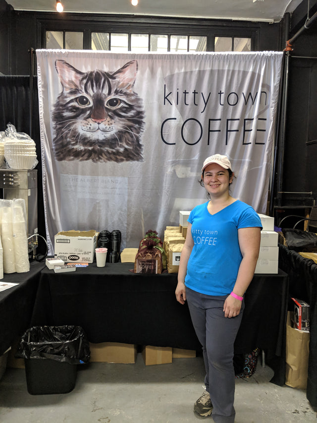 Zanetta Kok behind a Kitty Town Coffee table at a craft show
