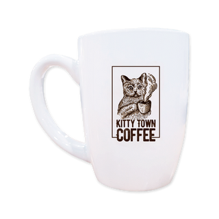 A white ceramic coffee mug with a printed design of a cat and the text 'Kitty Town Coffee'.