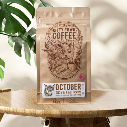 A bag of coffee sitting on a table in front of a leafy background