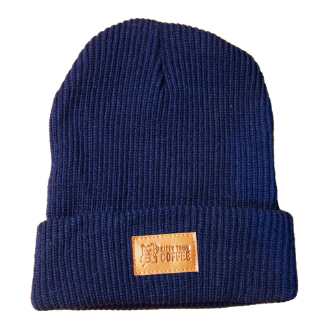 A navy blue knit beanie with a cuff and a rectangular brand tag on the side.