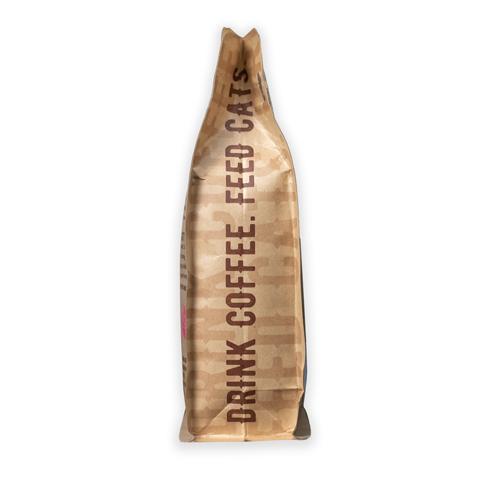 A side view of a 12oz bag of Kitty Town Coffee with the words, "Drink Coffee. Feed Cats."